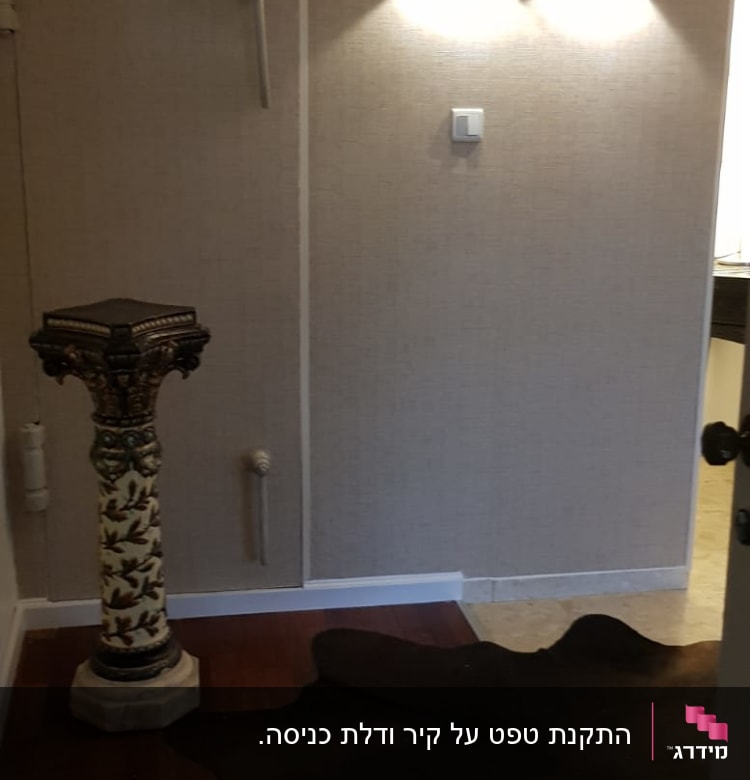 קיר עם טפט בהיר ושני גופי תאורה